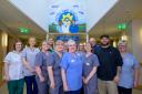 Staff at Marie Curie Hospice in Glasgow with artist EJEK at the new mural