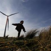 A young child plays among the wind turbines at Whitelee windfarm on Eaglesham moor. The windfarm is the largest in Europe.....Photograph by Colin Mearns..22 March 2012.