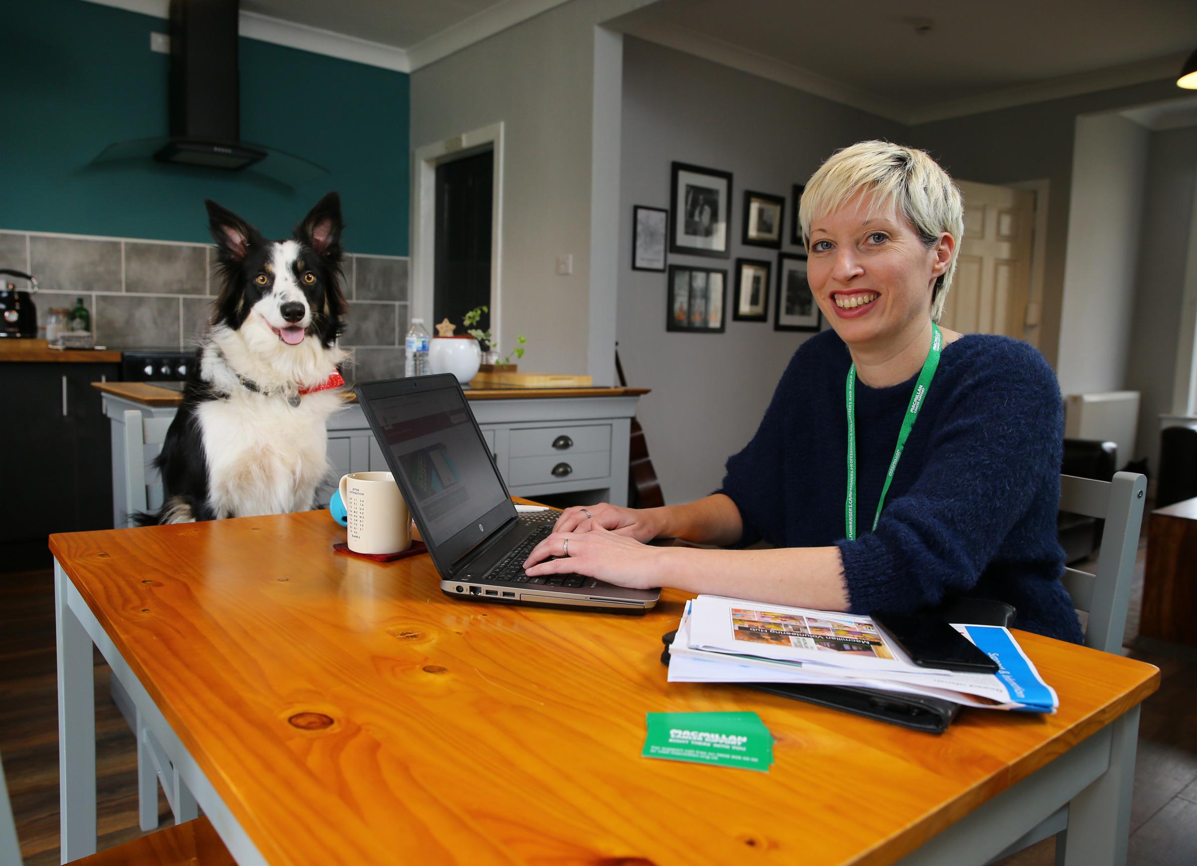 Annemarie Galbraith, Macmillan Cancer Support service manager pictured working at home in Glasgow with her dog Mischa Picture: Colin Mearns