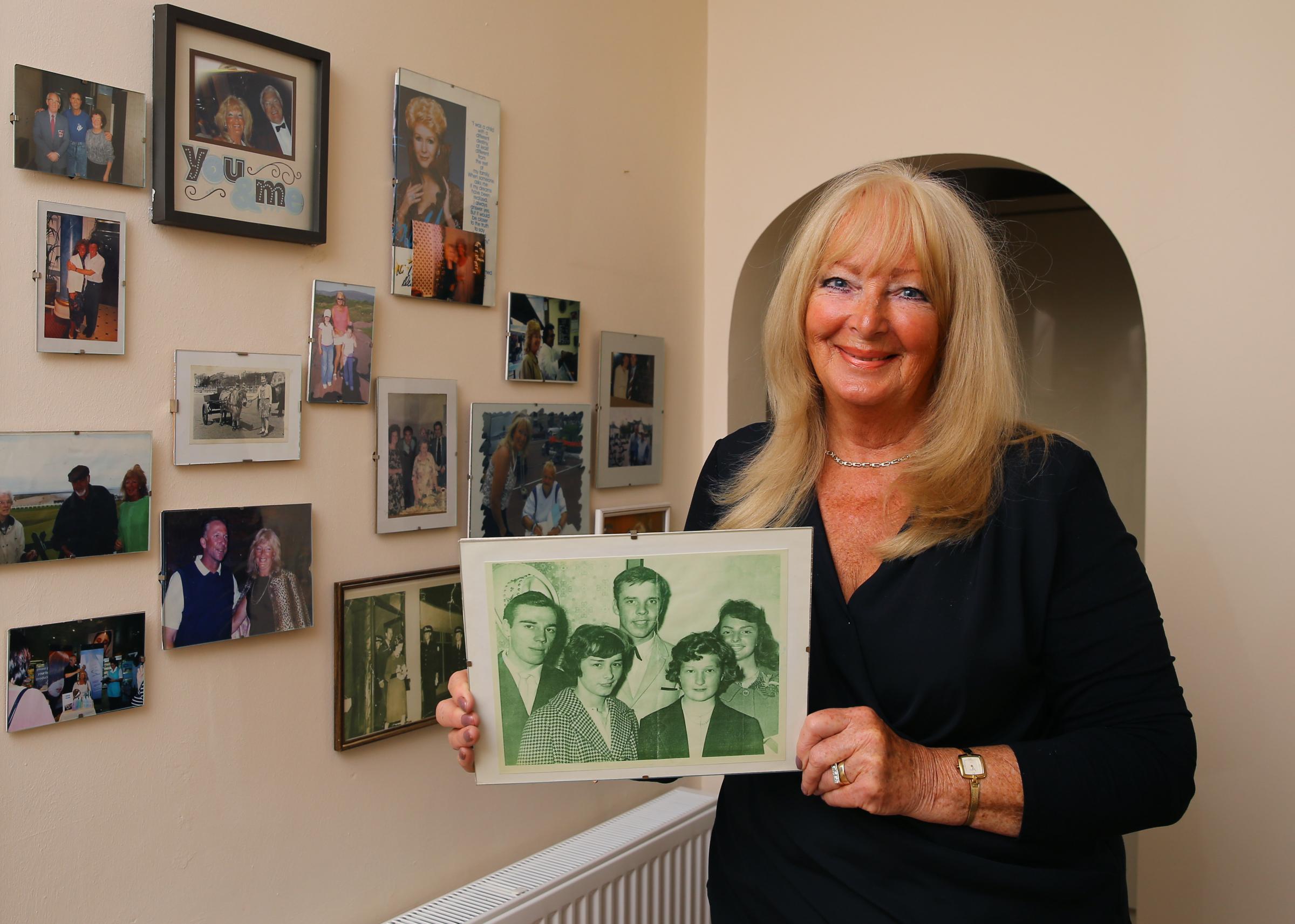 Margot Burkhill pictured at home in Glasgow next to a collection of photographs of herself with famous people. She is holding a photograph of herself with Marti Wilde after she won an Evening Times competition in 1960 to meet the singer at the Empire