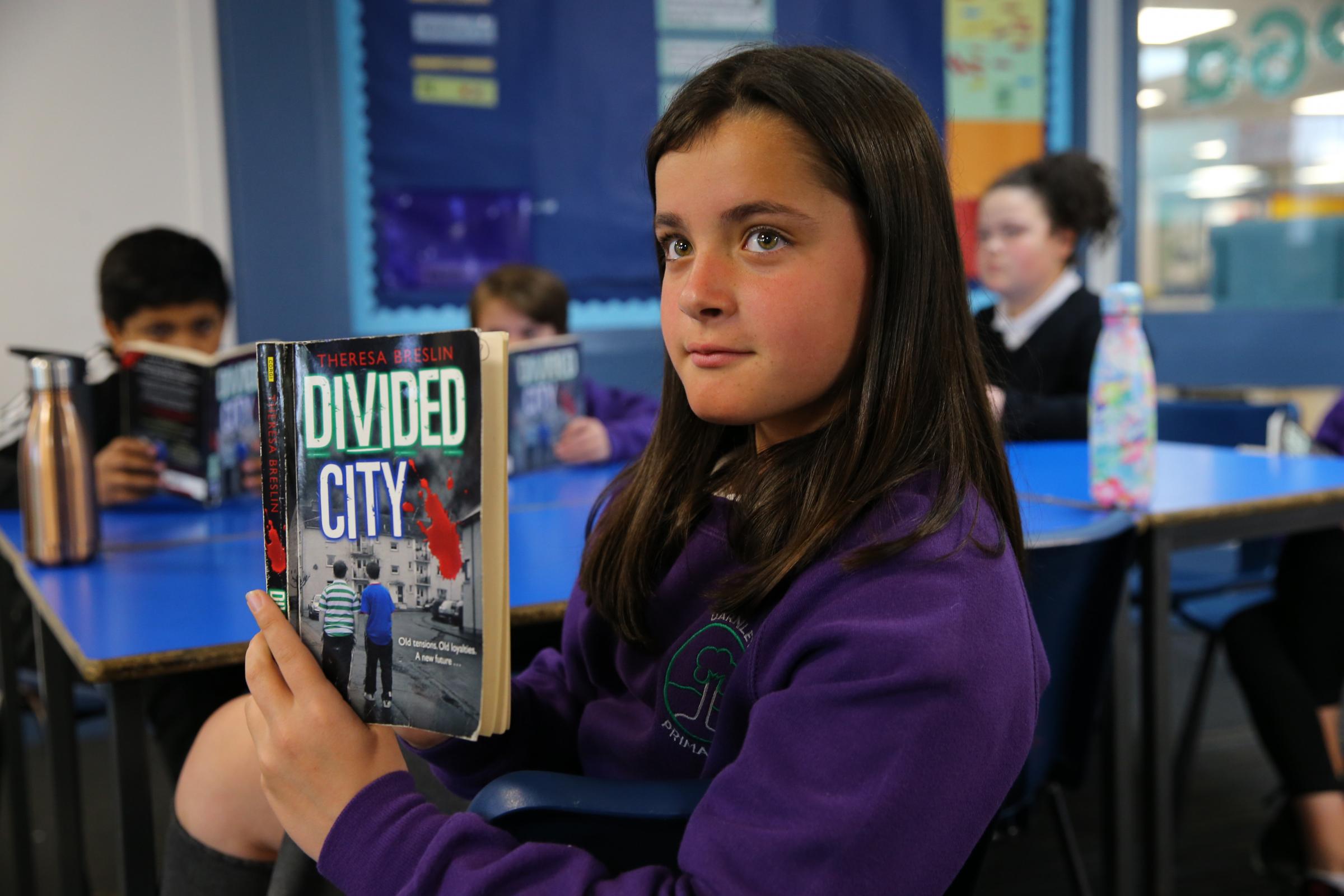 Darnley Primary school P6 pupil Abbie Watson with a copy of Divided City by Theresa Breslin Picture: Colin Mearns