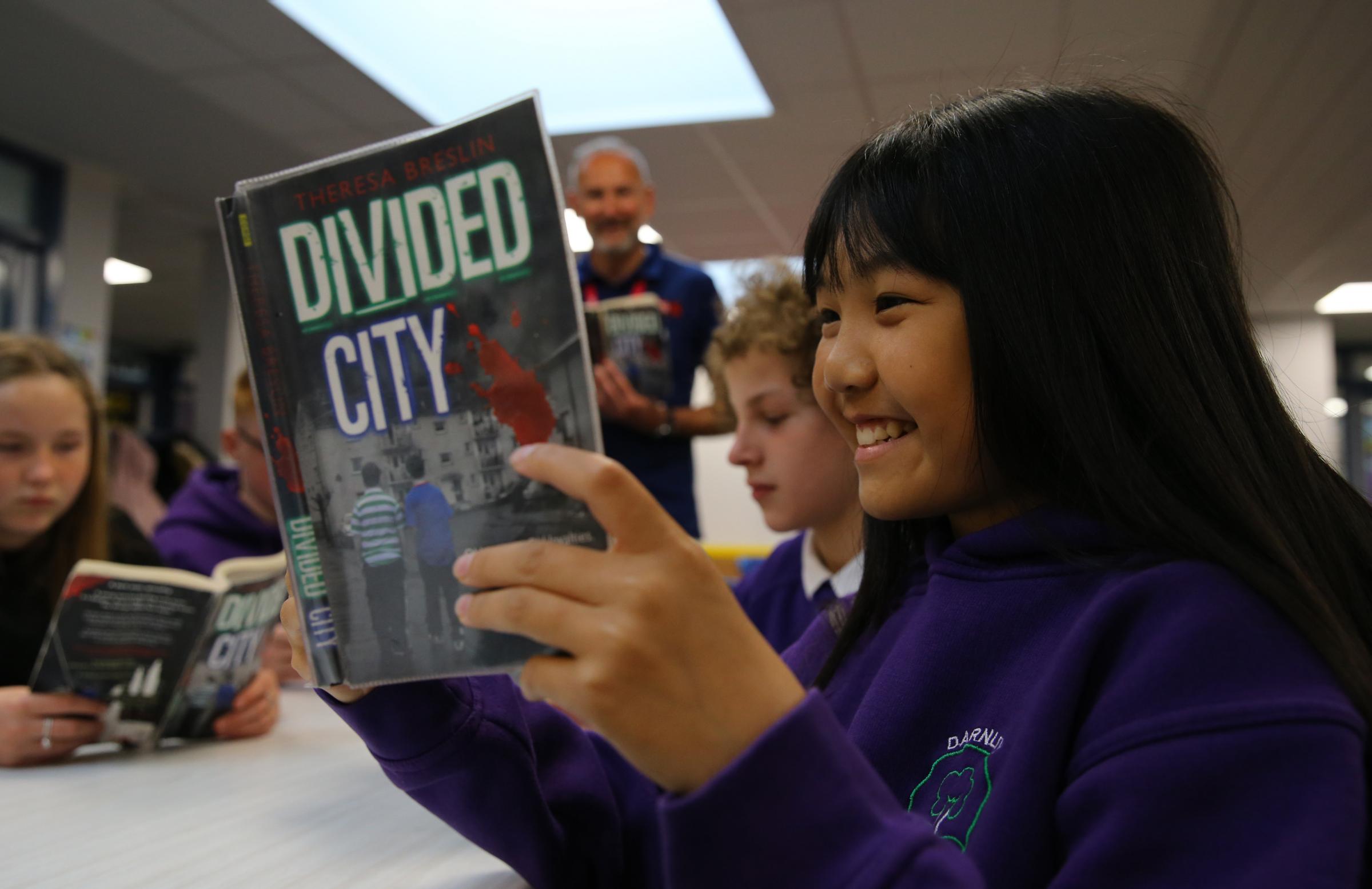 Darnley Primary school P pupil Constant Tho age 11 with a copy of Divided City by Theresa Breslin Picture: Colin Mearns