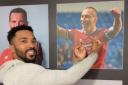 Shay Logan smiles as he delivers the fingers to a photo of Scott Brown