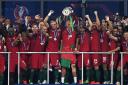 Cristiano Ronaldo of Portugal lifts the European Championship trophy after his side's win 1-0 against France at the Stade de France last night.