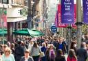 Crowds of people passing shops and businesses on Buchanan Street, one of Glasgow's busiest shopping streets..