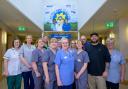 Staff at Marie Curie Hospice in Glasgow with artist EJEK at the new mural