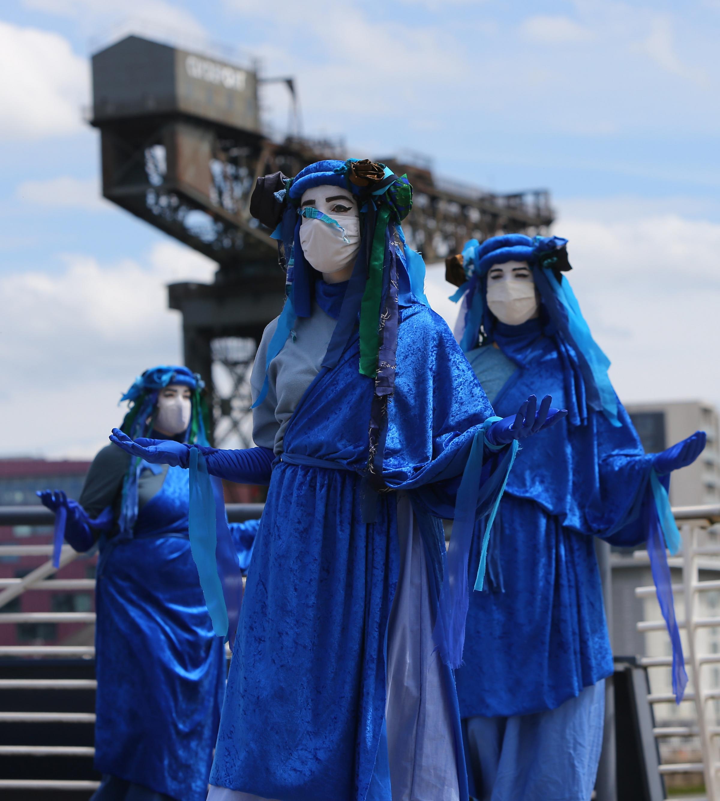 The Blue Rebels from Extinction Rebellion Scotland perform on Bells Bridge, Glasgow over the River Clyde to highlight sea level rise. COP 26 is due to take place at the SEC Campus in November. Photograph by Colin Mearns.