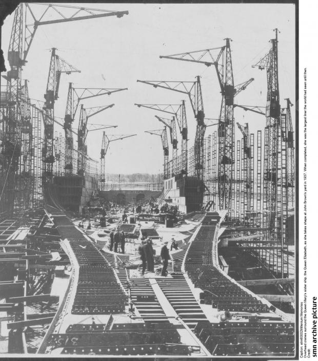 Glasgow Times: Overhead cranes surround the Queen Mary's sister ship. the Queen Elizabeth, as she takes shape at John Brown's yard in 1937. When completed, she was the largest liner the world had seen.