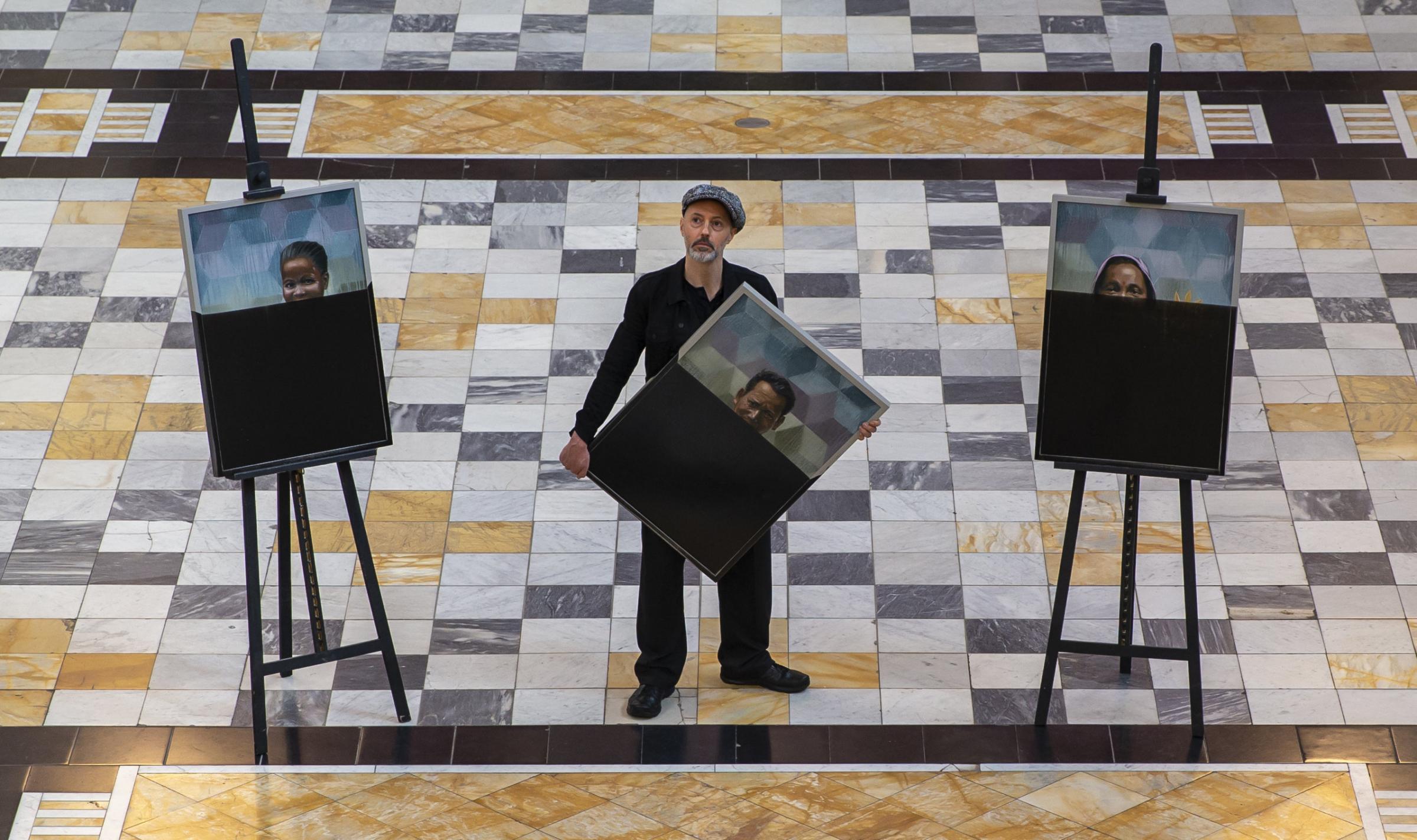Artist Iain Campbell pictured with his portraits, the faces partly obscured by black paint that were unveiled in Kelvingrove Art Gallery and Museum. Photograph by Colin Mearns.