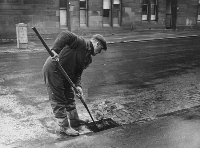 Cleansing Department worker cleaning a drain, c1950 Pic: Glasgow City Archives