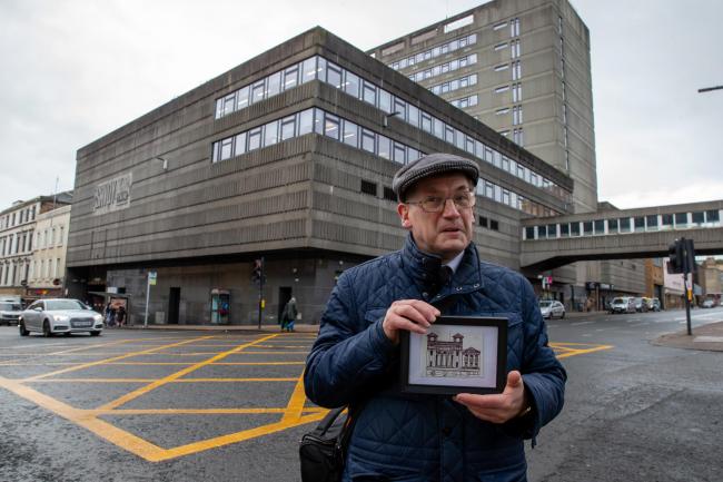 Brian D Henderson pictured in front of the Savoy Centre on Hope Street (Brian is standing at the crossroads of Renfrew and Hope Streets). He is holding a print of the Savoy Theatre that used to stand on the site where the Savoy centre now sits. The Savoy