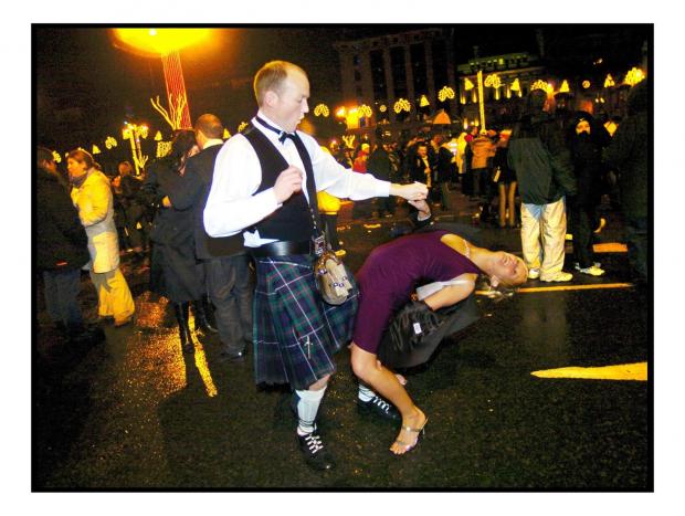 Glasgow Times: Micheal and Gillian Hully from West Cumbria dancing in the street after the bells in 2003. Photo: Kieran Dodds
