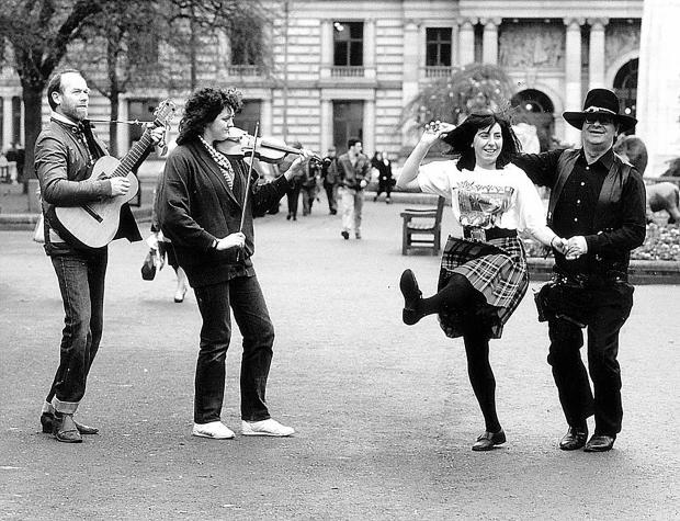 Glasgow Times: Jill Bunyan and Charles Bryce dance as guitarist Peter Bradford and fiddler Francis Birrell practise for the 1990 Hogmanay party in George Square in Glasgow. Pic: Newsquest