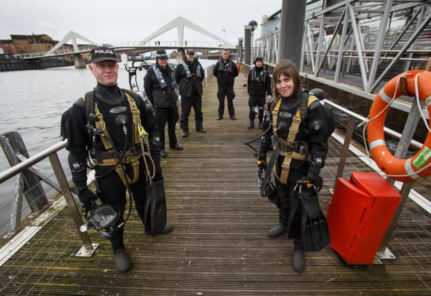 Glasgow Times: Members of the Police Dive and Marine unit pictured on the River Clyde at the Broomielaw in Glasgow. Divers Jim Miller, left and Louise Muir at right are pictured with colleagues, from left- Dougie Dorrington, Sgt Austin Burke, Rory Duncan and Robert