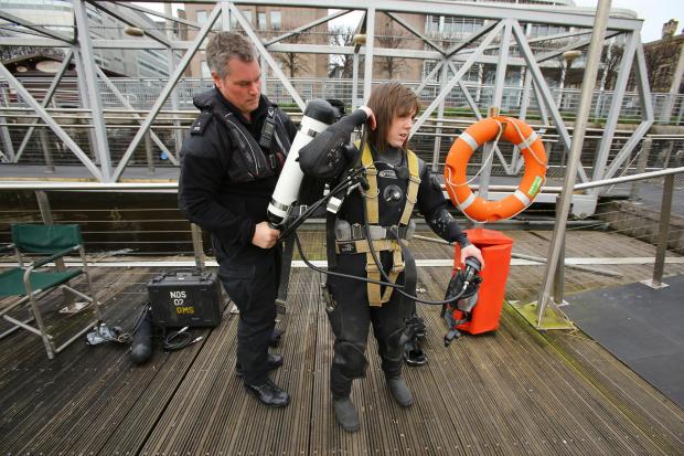 Glasgow Times: Members of the Police Dive and Marine unit pictured on the River Clyde at the Broomielaw in Glasgow. Pictured is  police diver Louise Muir getting ready to enter the water. She is being assisted by colleague Rory Duncan..Photograph by Colin Mearns.16