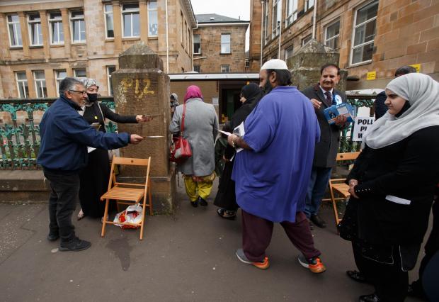 Glasgow Times: People arrive to vote at the polling station at Pollokshields primary school in the Southside of Glasgow