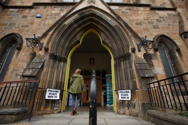 Glasgow Times: A voter walks in to the polling place at Queen's Park Govanhill parish church in the Southside of Glasgow