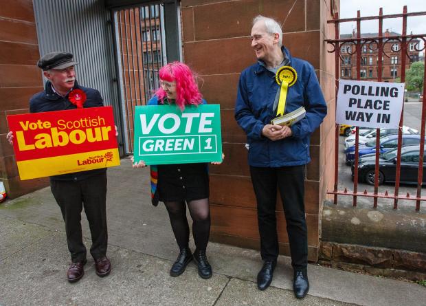 Glasgow Times: Pictured are Labour, Greens and SNP activists outside the polling place at Notre Dame primary school in Glasgow for the council elections
