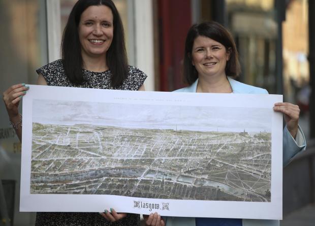 Glasgow Times: Glasgow City Heritage Trust curators Gemma Wild, right, and Rachel Kacir with the 1864 aerial map of Glasgow . STYPic Gordon Terris Herald & Times
