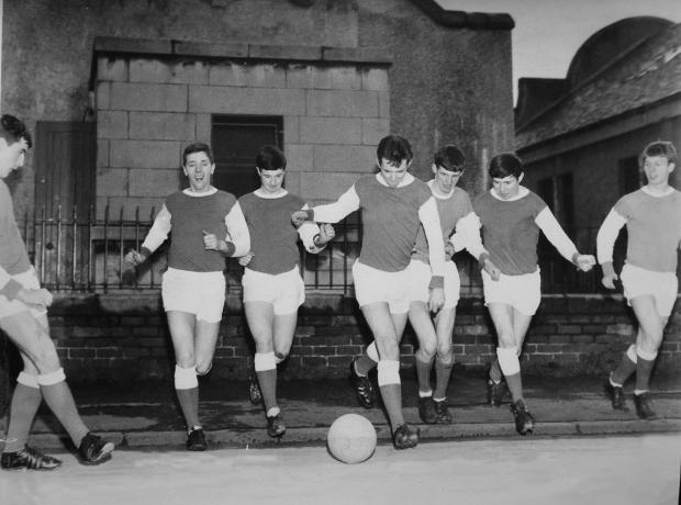 Glasgow Times: Young Possil YM footballers in Arsenal strips pictured in Possil in the 1960s.  Bobby Dinnie, now age 89, a retired football scout, was involved with the Possil YM football team for over 60 years and was responsible for discovering footballers Kenny
