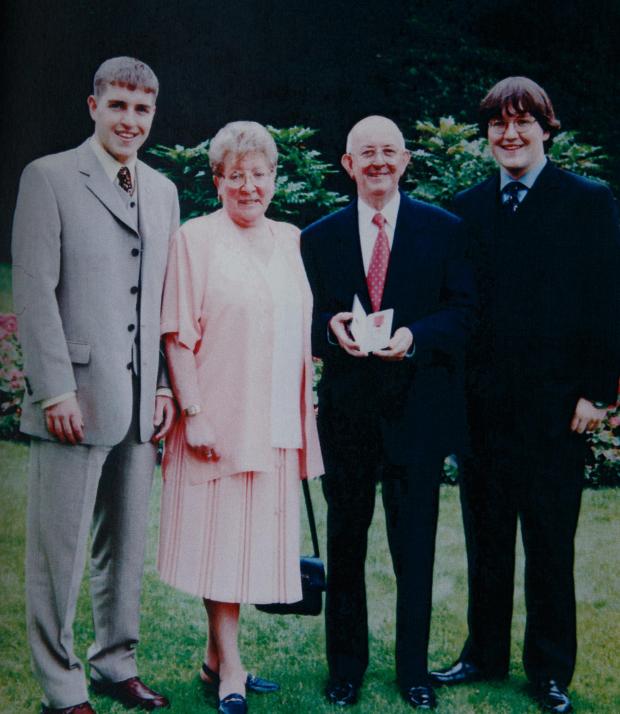 Glasgow Times: Bobby Dinnie pictured (with his MBE) with his wife Betty and sons Robert, left and Russell on the right. Bobby, a Korean war veteran,  now age 89, is a retired football scout, was involved with the Possil YM football team for over 60 years and was