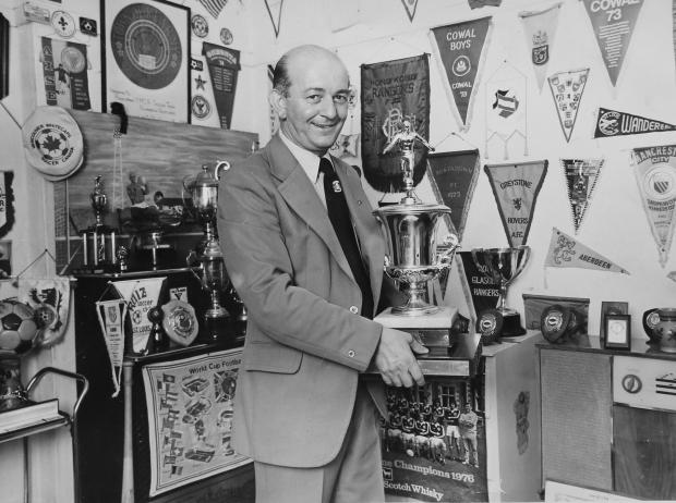 Glasgow Times: Bobby Dinnie pictured at home in the 1970s with a collection of trophies.  Bobby Dinnie, now age 89, a retired football scout, was involved with the Possil YM football team for over 60 years and was responsible for discovering footballers Kenny Dalglish,