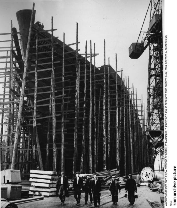 Glasgow Times: WORK PROGRESSES ON THE NEW EMPRESS OF BRITAIN AT FAIRFIELDS. THE BOW OF THE SHIP BEGINS TO TAKE SHAPE THOUGH STILL COVERED IN SCAFFOLDINGNewsquest 1955