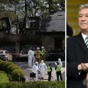 Emergency crews look over the aftermath of a blaze which tore through cars and the garage of Peter Lawwell's home