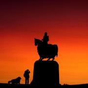 A person takes a photograph of the Robert the Bruce statue at sunset at the site of the battle of Bannockburn in Bannockburn, near Stirling | Photographer: Andrew Milligan