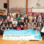 Children and staff at Holy Cross Primary celebrate winning the award.