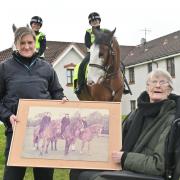 Sergeant Lisa Connelly, Police Scotland, presents Eleanor Dempster with a framed photograph of Eleanor and her two colleagues from the 1970s.