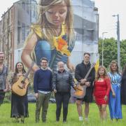 Guide Dakota Jones, singer-songwriter Olivia Haggarty, Campbell Parker of Glasgow Barons, CEO of Invisible Cities and tour guide Angie McTague with songwriter Jordan Robertson, singers Susy Cruz, Yasmeen Shah and Zakia Moulaoui Guery at Govan mural