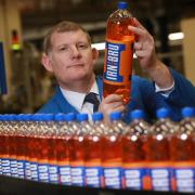 AG Barr chief executive Roger White pictured holding a bottle of Irn Bru