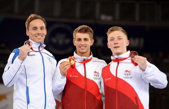 Daniel Keatings with his all-around silver medal for Team Scotland at Glasgow 2014 alongside Max Whitlock (centre) and Nile Wilson (left)