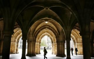 People walking among the cloisters beneath Bute Hall at the University of Glasgow.