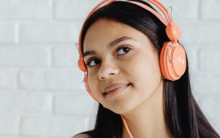 A girl listening to music on her headphones. Credit: Canva