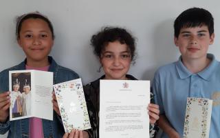 Yara Tadfi, Devon Wyer and Joseph Quail with their letters and cards from the King and Queen