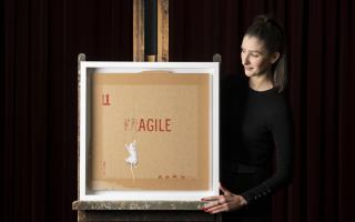 Auctioneer Amy Cameron with Banksy's AGILE, which is to go up for sale in Glasgow