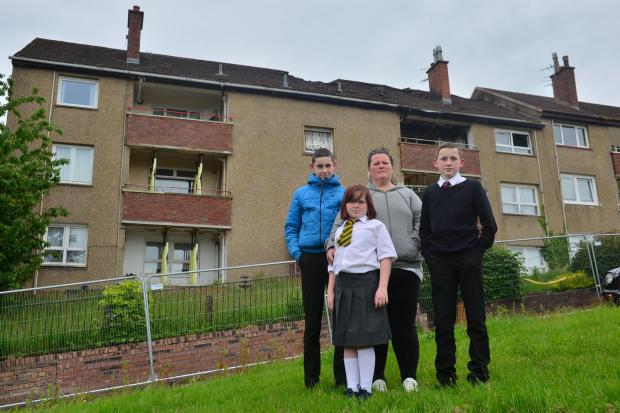 .Kelly Scullion and her children Aidan 15, Finn 13 and Keavy 11 stand outside their burnt out apartment block at Muirbrae way, Rutherglen. They have no idea when they will be able to return....Kirsty Anderson Newsquest Herald and Times .13/06/19..........